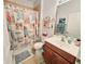 Charming bathroom with beach themed accessories, tile floors and a shower/tub combo at 13602 Abercrombie Dr, Englewood, FL 34223