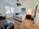Bright bedroom with a large window and a comfortable wrought iron bed frame and light wood style flooring at 13602 Abercrombie Dr, Englewood, FL 34223