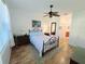 Sun-lit bedroom featuring tile flooring, ceiling fan and a wrought iron bed frame with an ensuite bath at 13602 Abercrombie Dr, Englewood, FL 34223