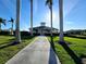 Scenic view of the community clubhouse framed by palm trees and lush landscaping at 13602 Abercrombie Dr, Englewood, FL 34223