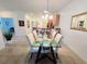 Dining room boasts a modern table with seating for six, and a view into the kitchen at 13602 Abercrombie Dr, Englewood, FL 34223