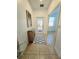 Inviting tiled entryway featuring a decorative front door, a console table and an adjacent room at 13602 Abercrombie Dr, Englewood, FL 34223