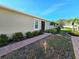 Villa exterior featuring a sidewalk leading to a screened door entry and manicured greenery at 13602 Abercrombie Dr, Englewood, FL 34223