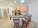 Kitchen with breakfast bar, light wood cabinets, tile backsplash, and recessed lighting at 13602 Abercrombie Dr, Englewood, FL 34223