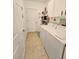 Practical laundry room featuring tile floors, washer, dryer and storage shelves for efficient organization at 13602 Abercrombie Dr, Englewood, FL 34223