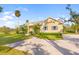 Charming home exterior featuring a well-manicured lawn, brick driveway, and lush landscaping at 13648 Heritage Way, Sarasota, FL 34240