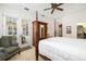 Main bedroom features a four-poster bed, ceiling fan, and access to an outdoor patio at 13648 Heritage Way, Sarasota, FL 34240