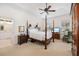 A cozy main bedroom features a four-poster bed, ceiling fan, and natural light from the window at 13648 Heritage Way, Sarasota, FL 34240