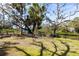 Lush backyard with mature trees, a charming bench, and a tranquil waterfront setting at 1531 Clower Creek Dr # Ha245, Sarasota, FL 34231