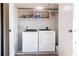 Functional laundry room with modern appliances, storage shelves, and tiled floor at 1531 Clower Creek Dr # Ha245, Sarasota, FL 34231