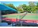 Outdoor tennis courts with green and red surface and trees in the background on a sunny day at 1531 Clower Creek Dr # Ha245, Sarasota, FL 34231