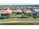 Aerial view of a waterfront residential property with lush greenery, serene lake, and a beautiful neighborhood at 17026 Loudon Pl, Bradenton, FL 34202