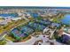 An aerial view of community tennis courts bordered by lush landscaping and surrounded by residential homes and lakes at 17026 Loudon Pl, Bradenton, FL 34202