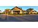 Front view of the Del Webb clubhouse with stone accents, palm trees, and meticulous landscaping at 17026 Loudon Pl, Bradenton, FL 34202