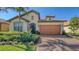 Inviting single-Gathering home showcasing a brick driveway, well-manicured lawn, and tiled roof at 17026 Loudon Pl, Bradenton, FL 34202