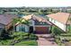 Inviting single-Gathering home featuring a brick driveway, tile roof, lush landscaping, and view of lake at 17026 Loudon Pl, Bradenton, FL 34202
