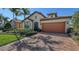 Appealing single-Gathering home featuring a brick driveway, well-manicured lawn, and tiled roof at 17026 Loudon Pl, Bradenton, FL 34202