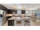 Gorgeous kitchen boasts a large island, stainless steel appliances, dark cabinetry, and pendant lighting at 17026 Loudon Pl, Bradenton, FL 34202