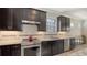 Well-equipped kitchen featuring modern appliances, granite countertops, and stylish dark wood cabinets at 17026 Loudon Pl, Bradenton, FL 34202