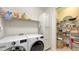 Laundry room with washer, dryer, wire shelves, and additional storage for household supplies at 17026 Loudon Pl, Bradenton, FL 34202