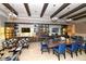 Library with a large wooden table surrounded by blue chairs, shelving, and TVs at 17026 Loudon Pl, Bradenton, FL 34202