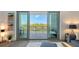 View from the balcony through sliding glass doors to the trees and buildings beyond at 1709 N Tamiami Trl # 408, Sarasota, FL 34234