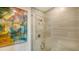 Modern glass enclosed shower, light gray shower tile and art on the wall at 1709 N Tamiami Trl # 408, Sarasota, FL 34234