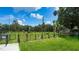View of the community dog park with flowers and well manicured lawn and black chain link fence at 1709 N Tamiami Trl # 408, Sarasota, FL 34234