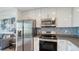 Bright kitchen featuring stainless steel appliances, white cabinets, and mosaic backsplash tiles at 1709 N Tamiami Trl # 408, Sarasota, FL 34234