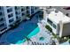 Aerial view of resort-style pool area, including hot tub, with lounge seating and modern buildings at 1709 N Tamiami Trl # 408, Sarasota, FL 34234