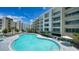 Resort-style pool surrounded by lounge chairs, palm trees, and modern buildings at 1709 N Tamiami Trl # 408, Sarasota, FL 34234