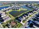 An aerial view of homes in a Gathering-friendly community with a lake, playground and landscaped greenery at 17119 Harvest Moon Way, Bradenton, FL 34211