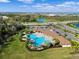 Aerial view of a large community pool with ample seating, palm trees, and beautifully landscaped surroundings at 17119 Harvest Moon Way, Bradenton, FL 34211