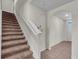 Carpeted staircase with white railing leading to the upper level of the home and tile flooring at 17119 Harvest Moon Way, Bradenton, FL 34211