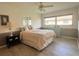 Cozy bedroom with wood floors, a ceiling fan, and natural light at 26137 Dunedin Ct, Punta Gorda, FL 33983