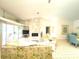 Bright living room featuring a unique stone fireplace, high ceilings, and sliding glass doors at 26137 Dunedin Ct, Punta Gorda, FL 33983
