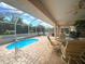 Relaxing screened-in lanai with pool, ceiling fans, and comfortable patio furniture at 26137 Dunedin Ct, Punta Gorda, FL 33983