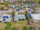 Aerial view of a home with gray roof, surrounded by lush greenery and neighboring houses on a sunny day at 2824 Silk Oak Dr, Sarasota, FL 34232