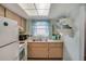 Bright kitchen featuring white appliances, wood cabinets, and a window with blue curtains at 2907 51St W Ave, Bradenton, FL 34205