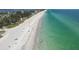 Aerial view of a white sand beach with clear turquoise water, ideal for sunbathing and enjoying the coastal scenery at 3007 Avenue E # A, Holmes Beach, FL 34217