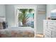 Bright bedroom with a view of private courtyard with seating and lush greenery at 3007 Avenue E # A, Holmes Beach, FL 34217