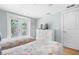 Bright bedroom with two twin beds, a dresser, and glass doors leading to an outside balcony at 3007 Avenue E # A, Holmes Beach, FL 34217
