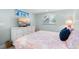 Bright bedroom featuring a large bed with coral patterned linens, a dresser with TV, and beach themed decor at 3007 Avenue E # A, Holmes Beach, FL 34217