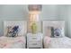 Cozy bedroom featuring twin beds, soft linens, and coastal artwork at 3007 Avenue E # A, Holmes Beach, FL 34217