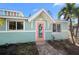 Charming cottage-style home with a vibrant coral door and well-manicured landscaping at 3007 Avenue E # A, Holmes Beach, FL 34217