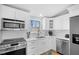 Modern kitchen featuring stainless steel appliances, white cabinetry, and a bright window at 3007 Avenue E # A, Holmes Beach, FL 34217