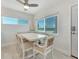 Bright dining area features a wooden table, cushioned seating, and a lovely ocean view from the window at 3015 Gulf Of Mexico Dr # 2, Longboat Key, FL 34228