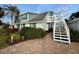 View of a two-story home with a wooden balcony accessible via exterior stairs at 3504 Estrada St, Sarasota, FL 34239