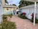 Exterior brick courtyard featuring lush tropical landscaping, connecting the house to the laundry building at 3504 Estrada St, Sarasota, FL 34239