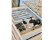 Organized kitchen drawer featuring a utensil organizer, can opener, and bottle opener with gray speckled countertop at 3504 Estrada St, Sarasota, FL 34239